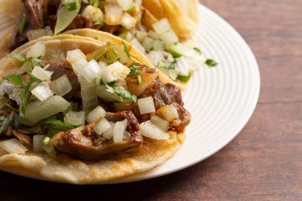 istock Three Buche Street Tacos in a Row on a Wooden Table 1382399471