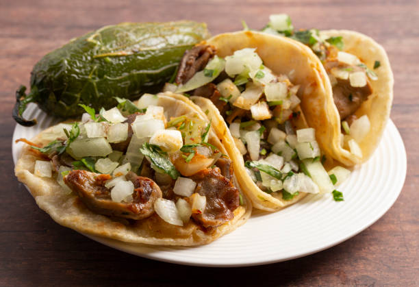 istock Three Buche Street Tacos in a Row on a Wooden Table 1382399476