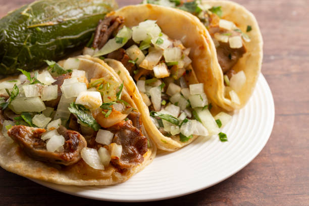 istock Three Buche Street Tacos in a Row on a Wooden Table 1382399996