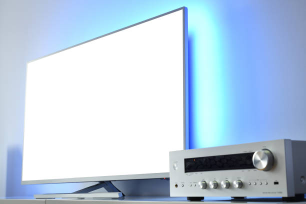 istock Large backlit LED TV with white screen and audio receiver in a modern apartment. 1382400537