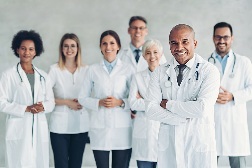 Multiracial group of doctors standing together and looking at camera