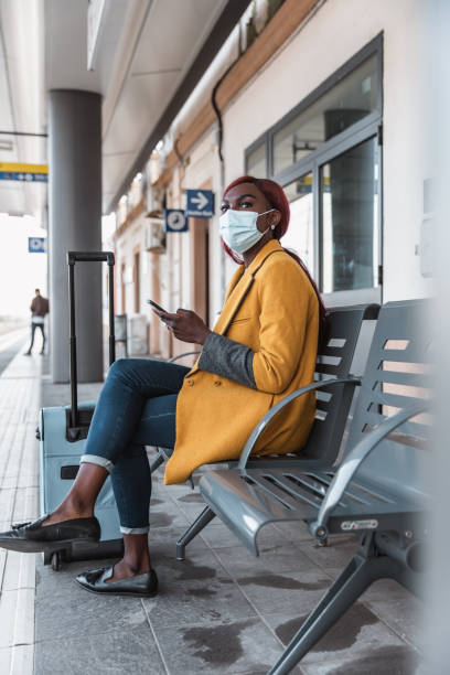 istock Woman at the train station waiting on platform 1382410264