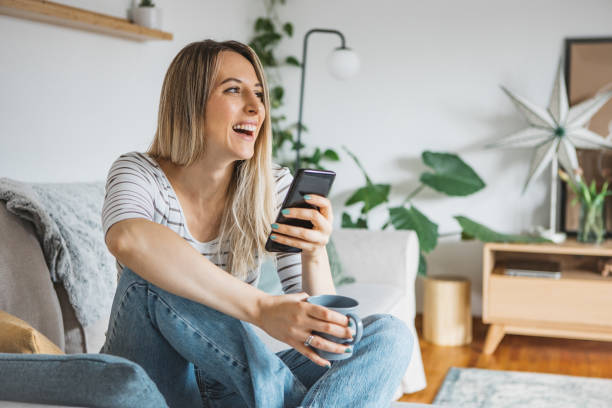 istock Young woman using cell phone on a couch at home 1382415123