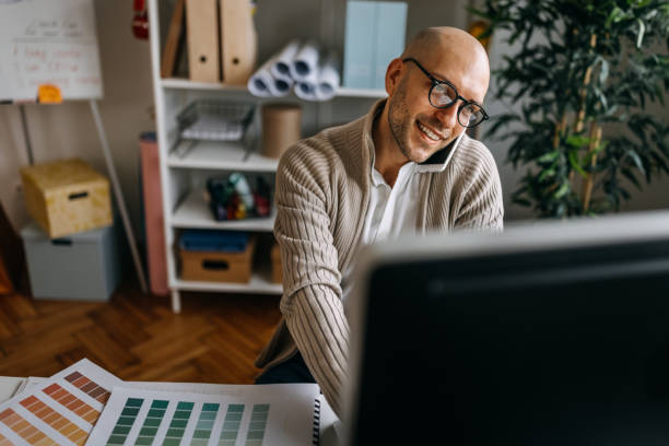 istock Male interior designer talking over smart phone in office 1382429996