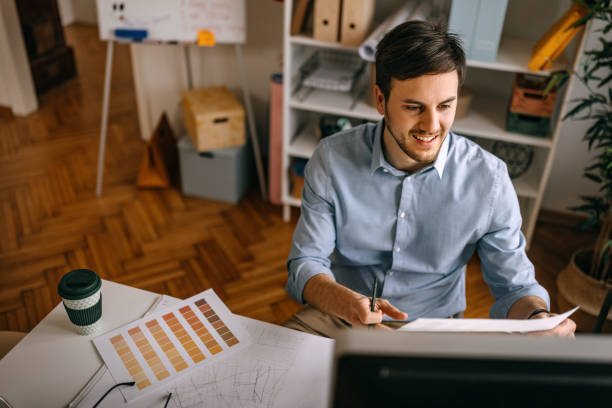 istock Male interior designer analyzing color chart in office 1382431095