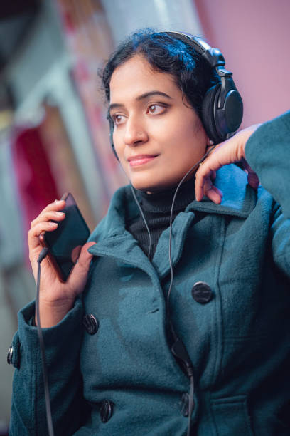 Happy woman enjoys music/podcast through headphones. stock photo
