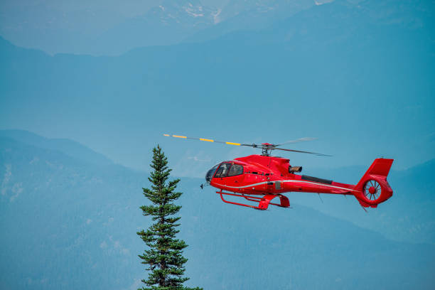 istock Red rescue helicopter flying in a mountain environment. 1382455058