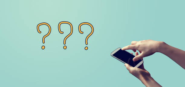 istock Question marks with person holding smartphone 1382458737