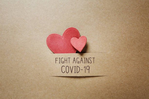 istock Fight Against Covid-19 message with small hearts 1382459169