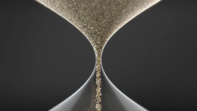 Hourglass. Sands move through hourglass. Sand glass close-up on background.