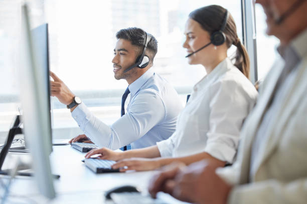 istock Shot of call center agents wearing headsets while sitting at their computers 1382470983