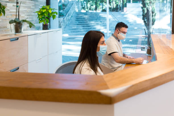 istock Colleagues in masks working at reception desk 1382482205