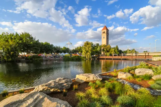 Photo of Afternoon view of Riverfront Park along the Spokane river with the clocktower and pavilion in view during an annual festival in Spokane, Washington, USA.