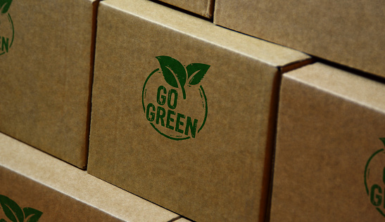 Go green and eco friendly symbol stamp printed on cardboard box. Co2 neutral, ecology, environment, nature and climate concept.