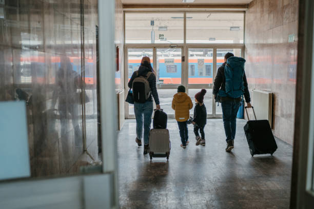 familia con dos hijos en la estación de tren - emigración e inmigraci�ón fotografías e imágenes de stock