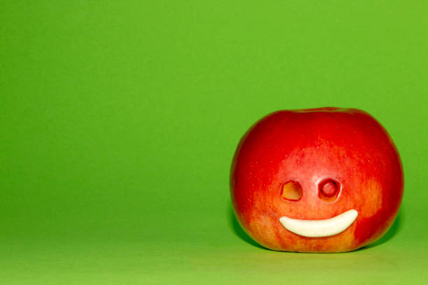 An apple smiling to other one, that is concealing its sadness behind a smily mask