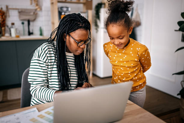 istock Mother assisting daughter in writing homework at home 1382494357