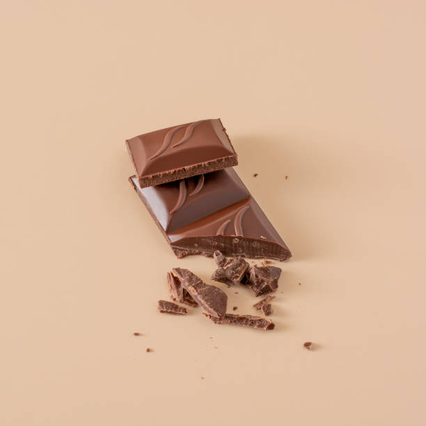 istock pieces of chocolate and chocolate chips on a sand-colored background. 1382499816