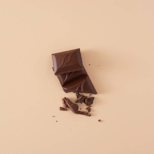 istock pieces of chocolate and chocolate chips on a sand-colored background. 1382510123