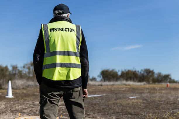 istock Mature intructor on his back with reflective jacket looking away at open field 1382511717