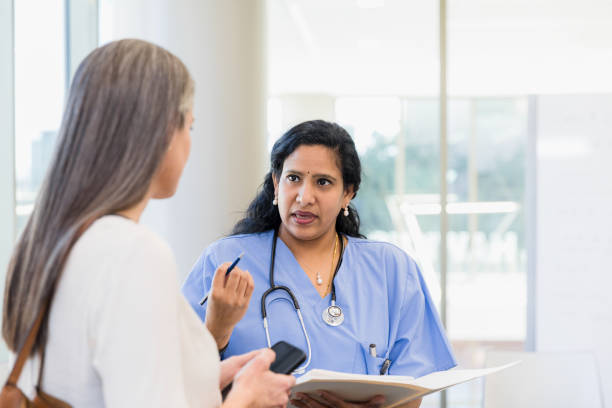 istock Doctor explains treatment plan as woman uses phone for notes 1382523407