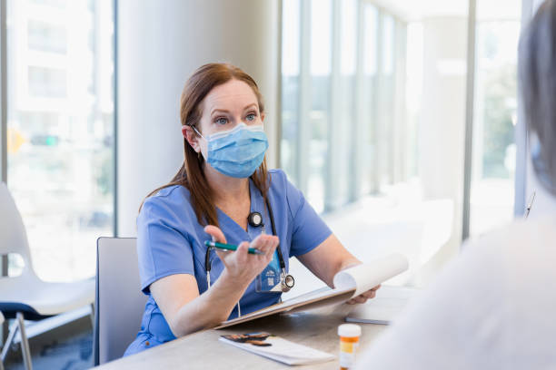 istock Female doctor with protective mask gestures while talking to patient 1382523417
