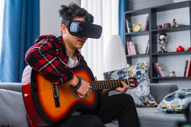 boy learning how to play guitar by using virtual reality headset