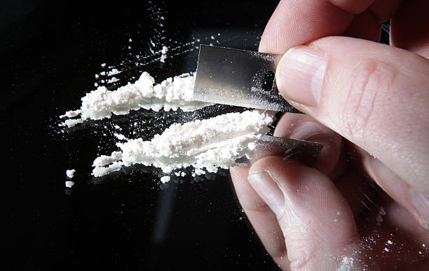 cocaine cutting drugs addiction cocaine or other drugs cut with razor blade on mirror. hand dividing white powder narcotic cocaine photos stock pictures, royalty-free photos & images