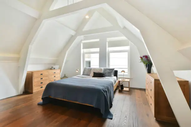 luxurious double bed with beautiful wooden furniture but located on the attic floor