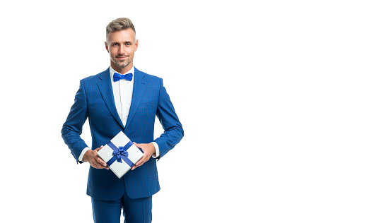 cheerful man in blue bow tie suit hold present box isolated on white with copy space.