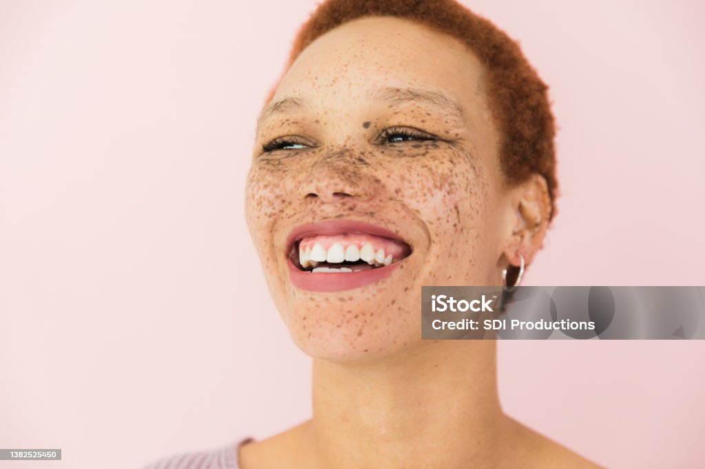 Toothy smile The gorgeous woman has a toothy smile while she laughs. Freckle Stock Photo