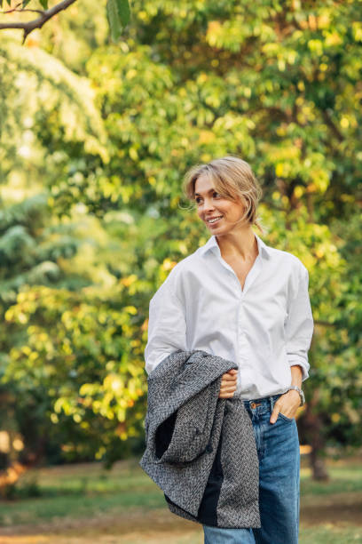 istock Smiling young woman walking in the park 1382536708