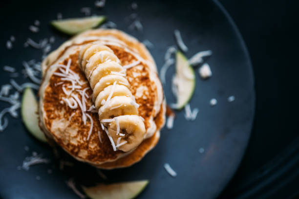 Directly above the delicious pancake with banana Close-up of a banana pancakes green apple slice overhead stock pictures, royalty-free photos & images