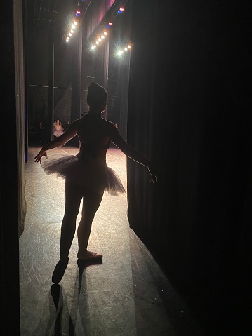 Photo of a ballerina backstage, waiting for the show to begin and anticipating her performance.