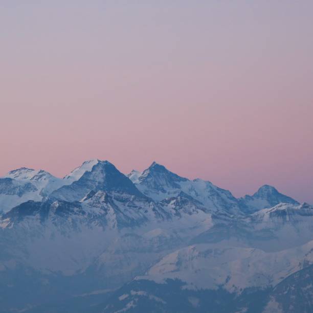 Pink sky over Eiger, Monch and Jungfrau. stock photo