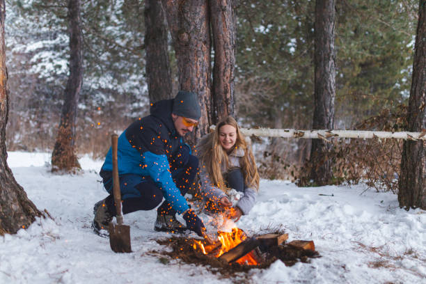 istock Two young friends sitting beside a campfire while roasting marshmallows and having fun 1382649589