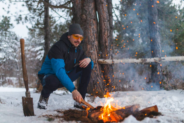 istock Young male starting a campfire outdoors during winter 1382649601