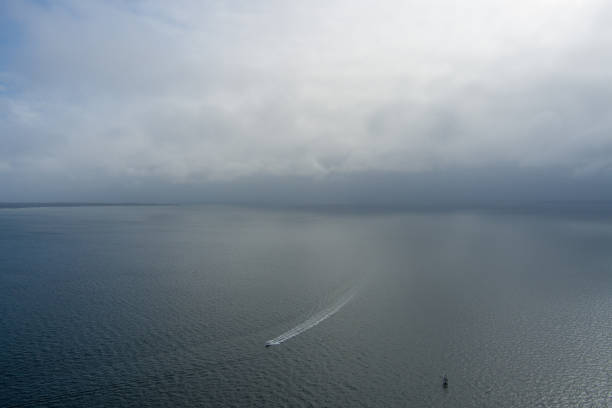 Aerial view of a lone boat evading a storm on Pensacola Bay in Pensacola, Florida