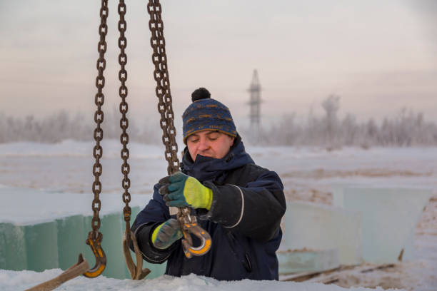 istock Fitter in a blue jacket works with a chain metal sling 1382687760