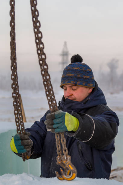 istock Fitter in a blue jacket works with a chain metal sling 1382687762
