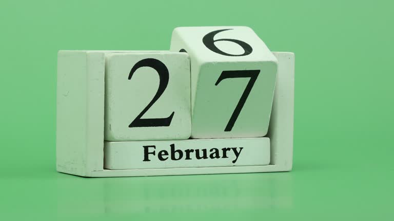 February month calendar 4K Stop motion fast pace of time during the month by handmade wood calendar with date month and day on a wooden table