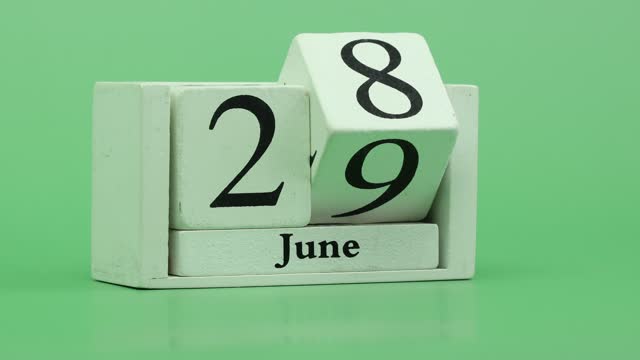 June month calendar 4K Stop motion fast pace of time during the month by handmade wood calendar with date month and day on a wooden table