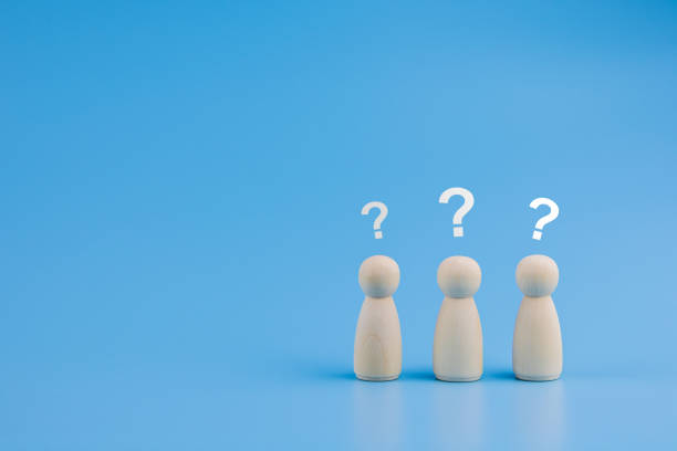 istock wooden doll with question mark on background. 1382703302