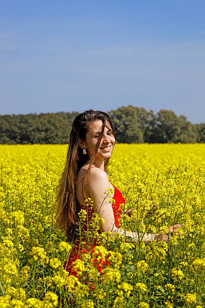 Young woman with red dress in the sea of ​​flowers stock photo