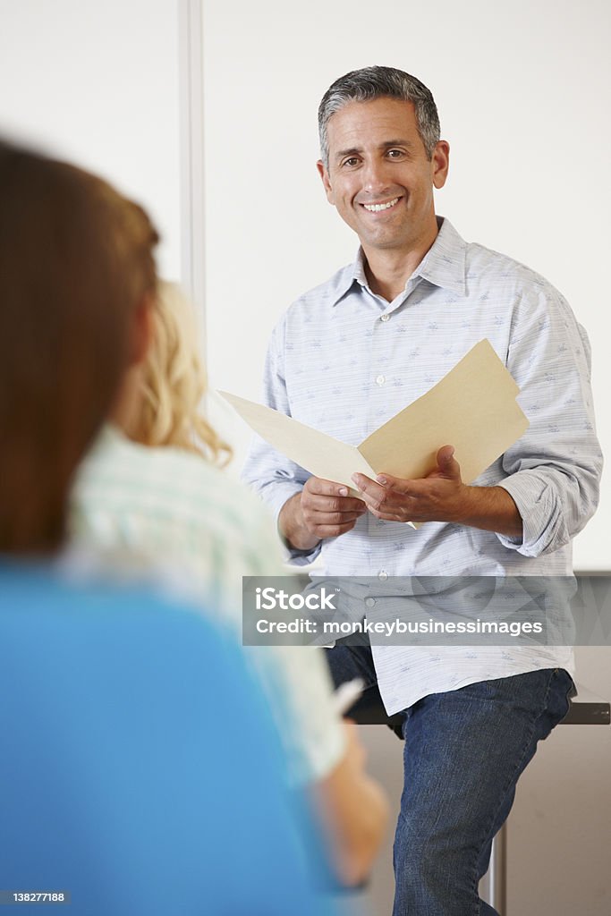 Tutor with class of students Tutor talking with class of students in classroom Professor Stock Photo