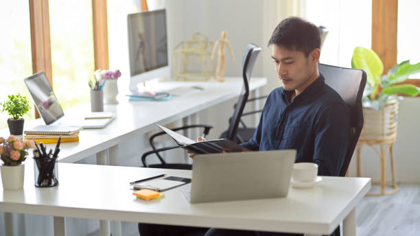 istock Focused Asian young businessman is working in the office 1382784455