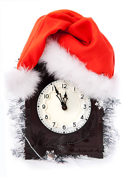 Relógio em christmass chapéu sobre fundo branco - foto de acervo