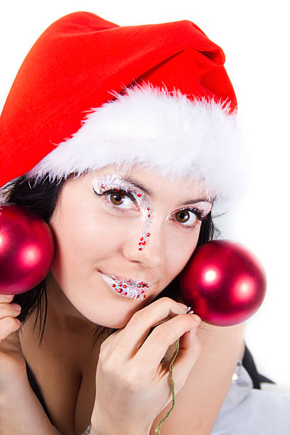 Carnival girl in christmass hat holds a red spheres stock photo