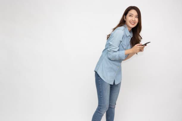 istock Young asian woman using mobile phone and feeling surprised isolated over white background 1382800150