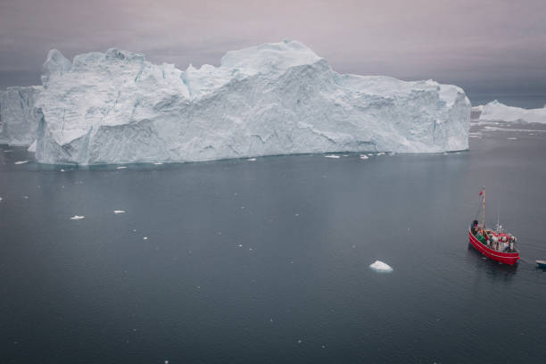 istock SMALL BOAT SAILING BETWEEN BIG ICEBERGS FROM AERIAL VIEW 1382808969